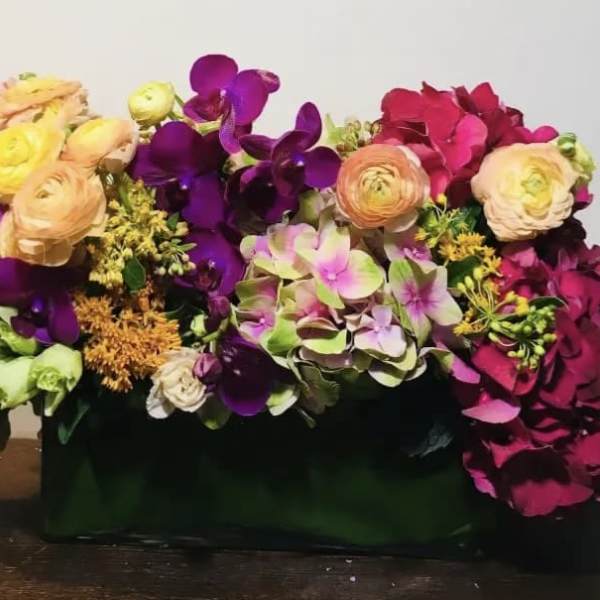 Colorful floral arrangement in a dark rectangular container