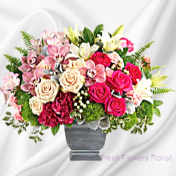Mixed pink and white flower arrangement in a gray vase
