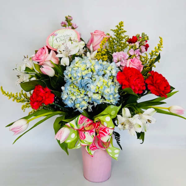 Pink and red mixed bouquet in a pink vase with a ribbon