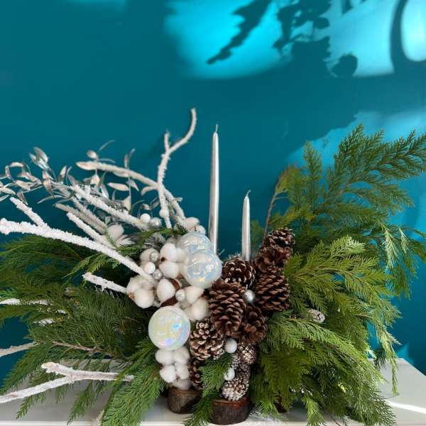 Winter centerpiece with pinecones, white accents, and silver candles