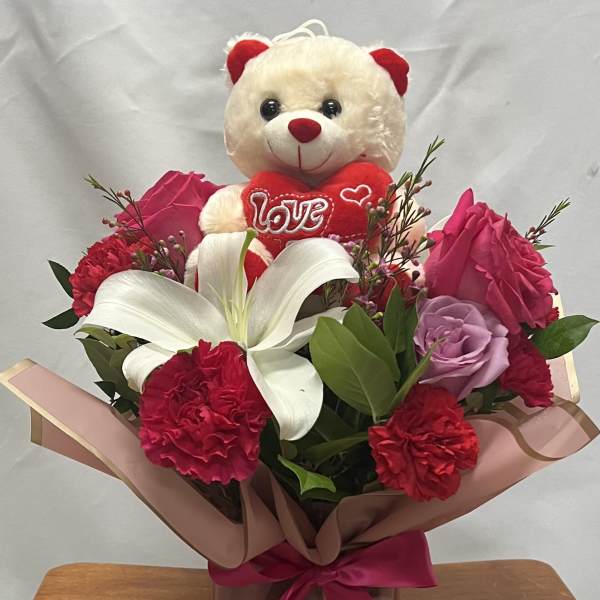 Bouquet with a teddy bear, roses, carnations, and a white lily