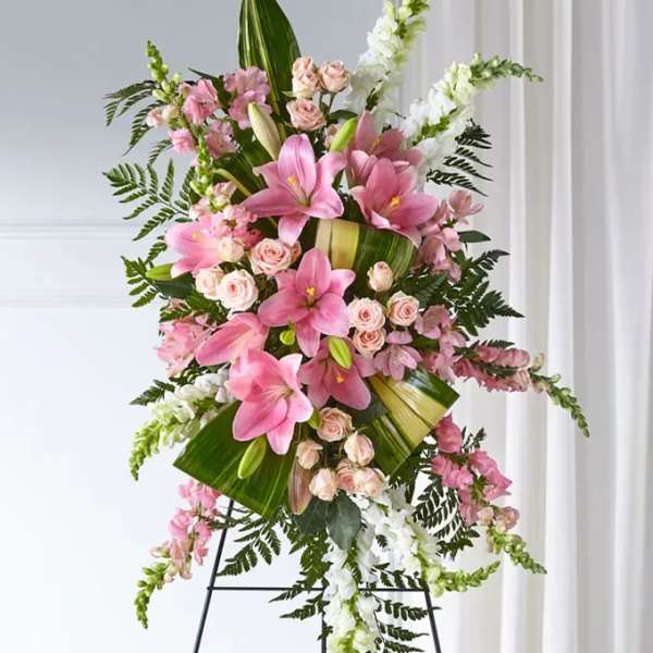Tall standing floral spray with pink lilies, pale roses, and white snapdragons