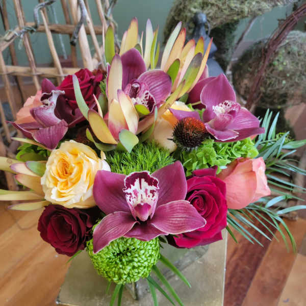 Mixed bouquet with orchids, roses, and green chrysanthemums in a vase