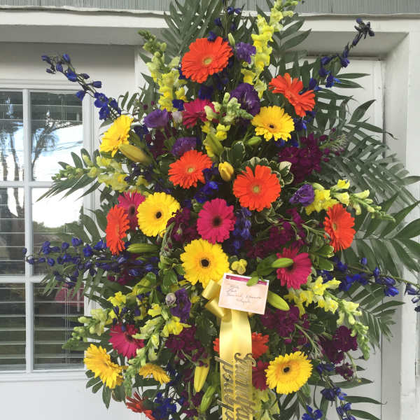 Large standing spray of multicolored gerbera daisies and snapdragons