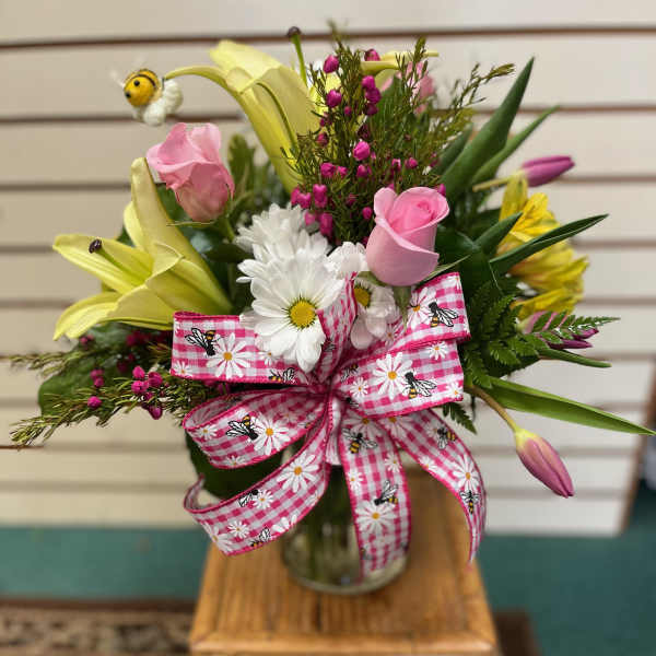 Mixed bouquet in a glass vase with pink ribbon and yellow lilies