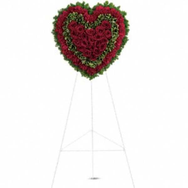 Heart-shaped standing floral wreath of red roses on an easel