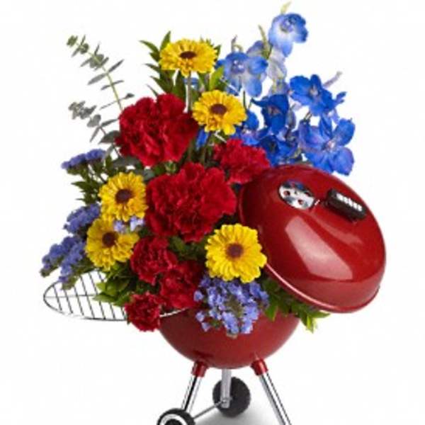 Red grill-shaped planter filled with colorful flowers