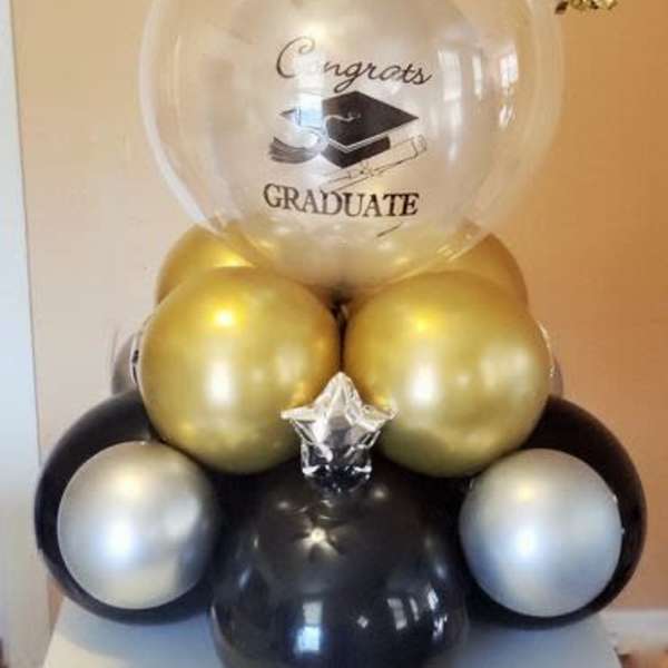Graduation balloon arrangement with a clear congratulatory balloon and gold and black balloons
