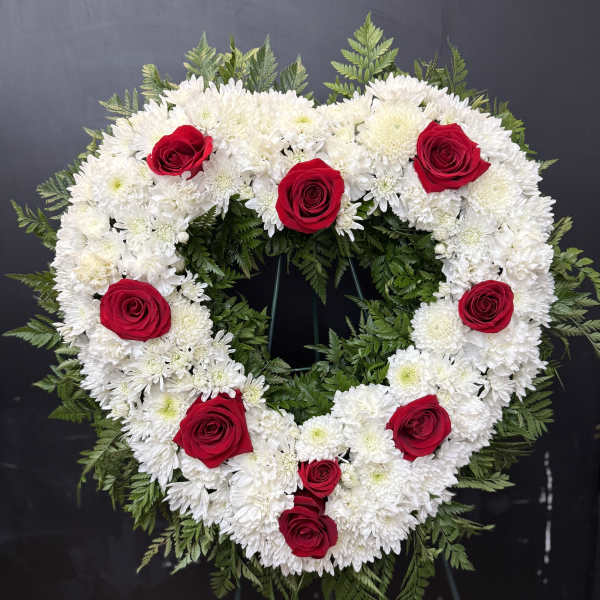 Heart-shaped floral wreath of white flowers with red roses