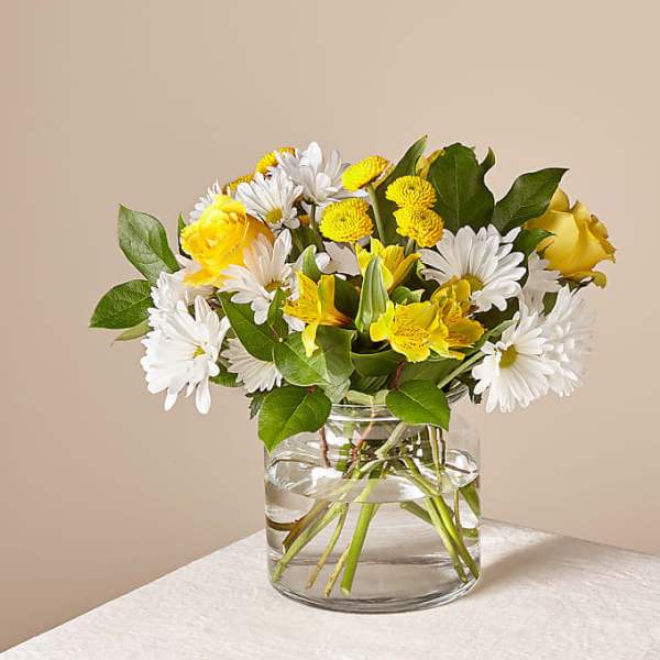 Yellow and white mixed bouquet in a clear glass vase