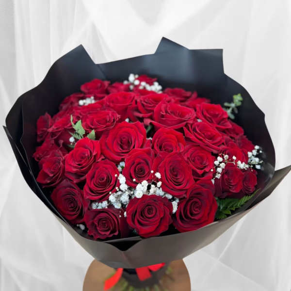 Bouquet of red roses with baby's breath in black wrapping