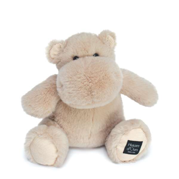 Plush beige teddy bear with a small logo tag on one foot