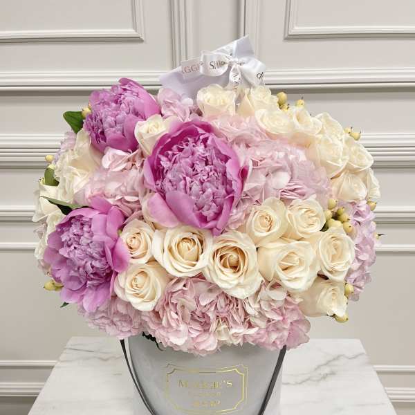 Pink and cream bouquet in a gray hatbox with ribbon
