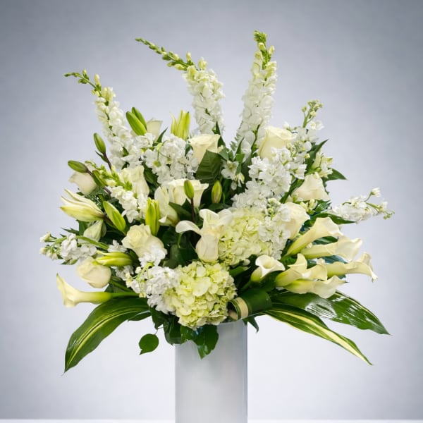 White floral arrangement in a tall glass vase