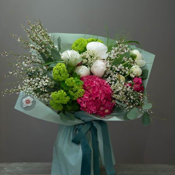 Bouquet of pink and white flowers wrapped in pale blue paper
