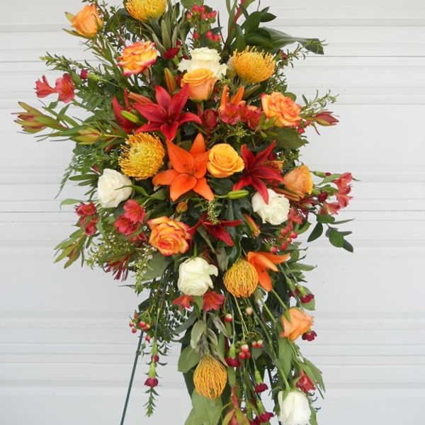 Tall standing floral spray with orange, red, and white blooms