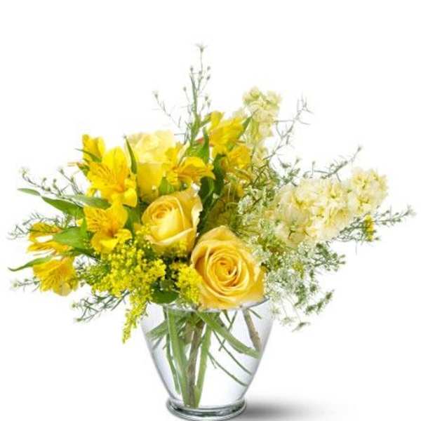 Yellow roses and alstroemeria in a clear glass vase