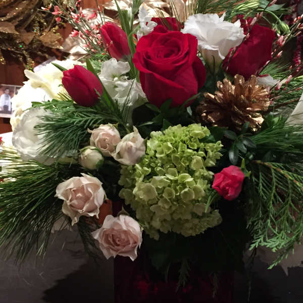 Bouquet of red and white roses with green hydrangea and pine accents