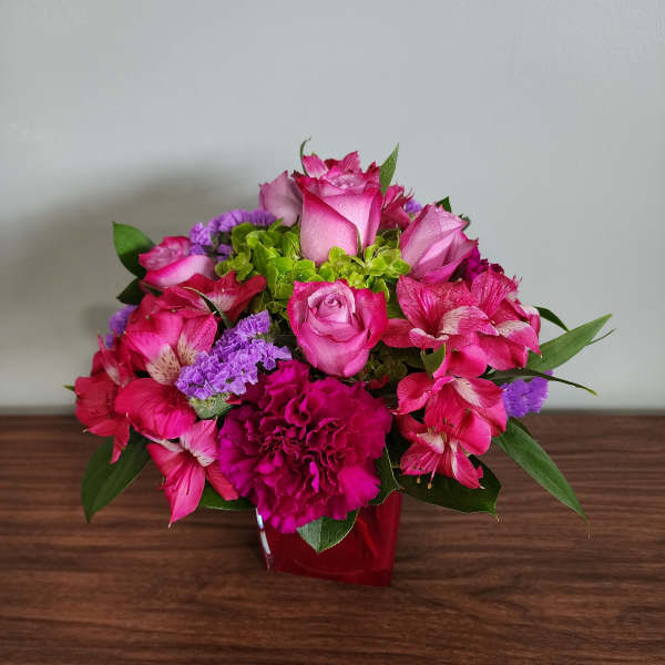 Pink roses and alstroemeria in a red vase