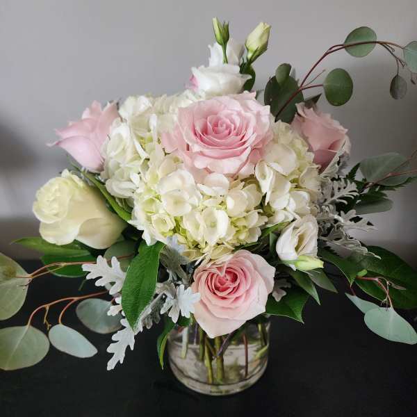 Pink and white roses with hydrangeas in a glass vase