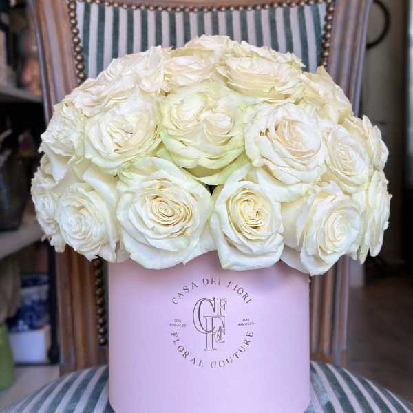 Cream rose arrangement in a pink round box