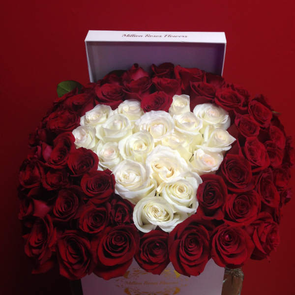Heart-shaped arrangement of red and white roses in a white box