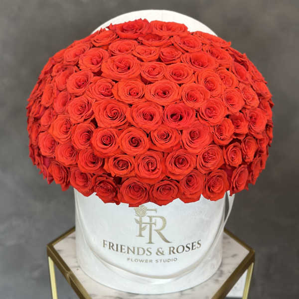 Large red rose arrangement in a white round hat box