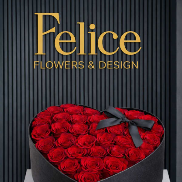 Heart-shaped box filled with red roses and a black ribbon bow