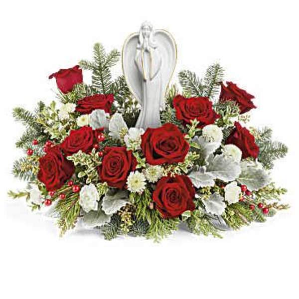 Red roses arranged around a white angel figurine