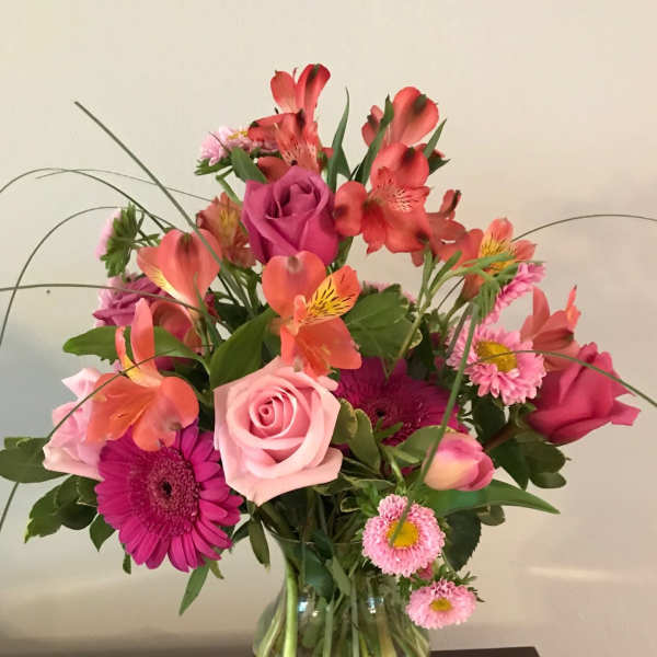 Pink and coral mixed bouquet in a clear glass vase
