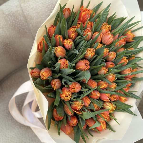 Bouquet of orange tulips wrapped in cream paper