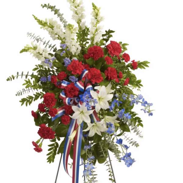 Standing floral spray with red, white, and blue flowers on a metal easel