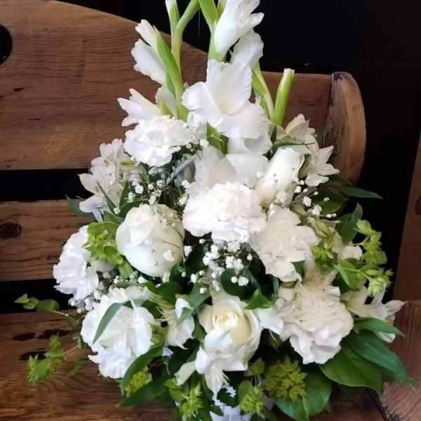 White floral arrangement with tall gladiolus and mixed blooms in a basket