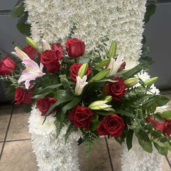 White floral standing spray with red roses and pink lilies