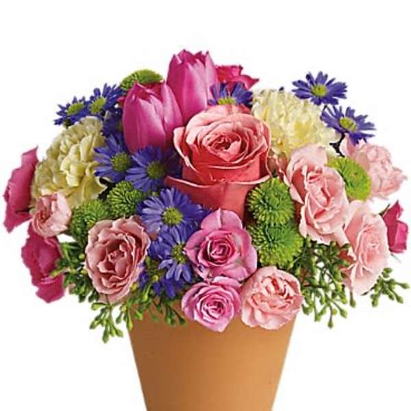 Mixed bouquet of pink roses, tulips, and purple daisies in a tan pot