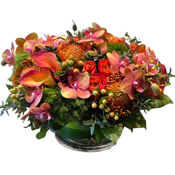 Orange and pink floral arrangement in a glass bowl vase