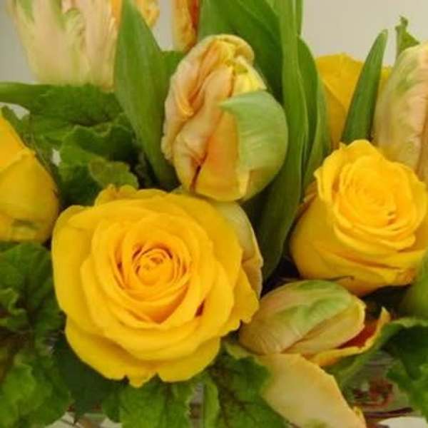 Yellow roses and tulips arranged in a bouquet.
