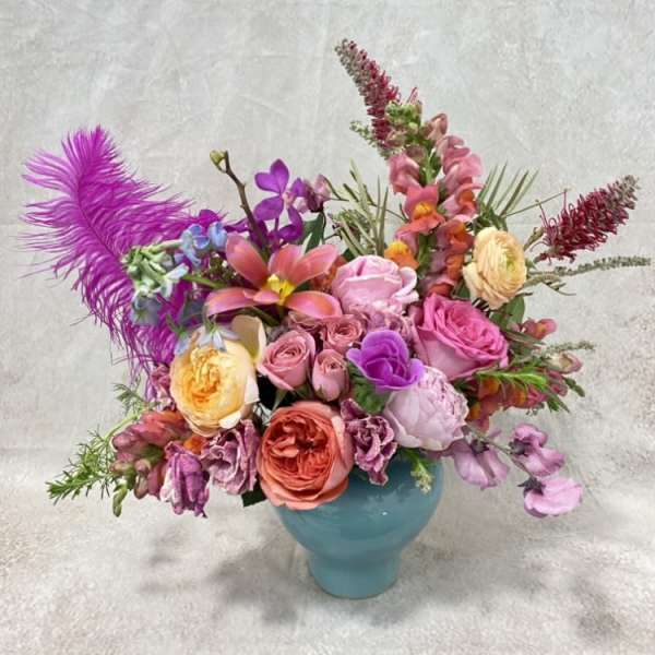 Colorful mixed flower arrangement in a blue vase