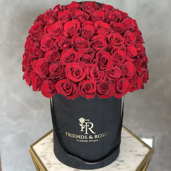 Large bouquet of red roses in a black hat box
