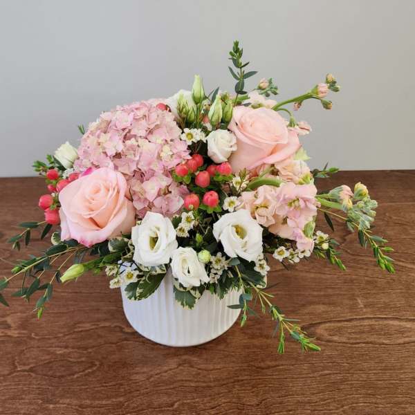 Pink and white floral arrangement in a white vase