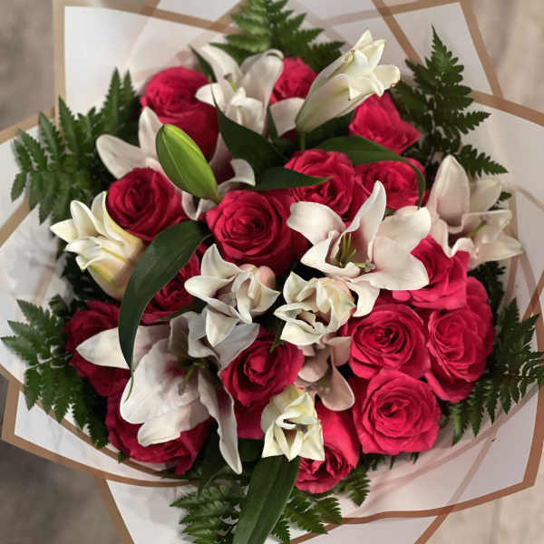 Bouquet of hot pink roses and white lilies wrapped in paper