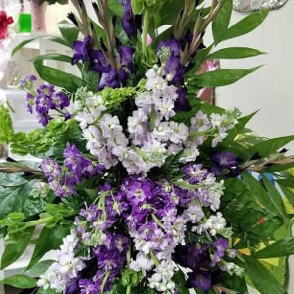 Tall purple and white floral standing spray on an easel