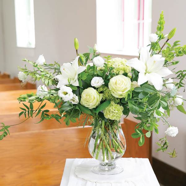 White lilies and roses in a clear glass vase
