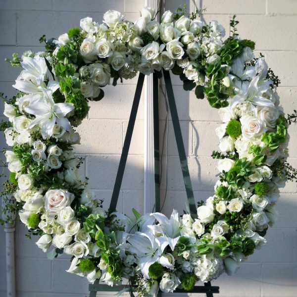 White floral wreath on a black easel