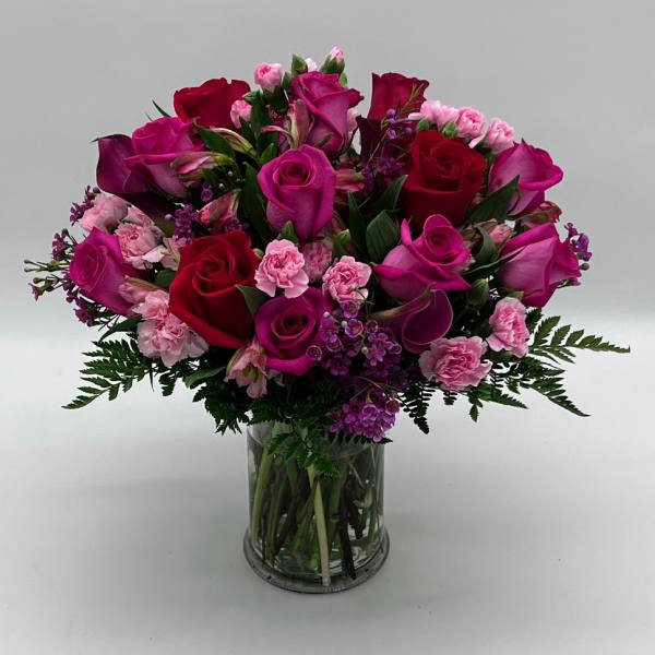 Bouquet of pink and red roses with carnations in a glass vase