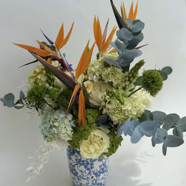 Bouquet of tropical flowers in a blue-and-white ceramic vase