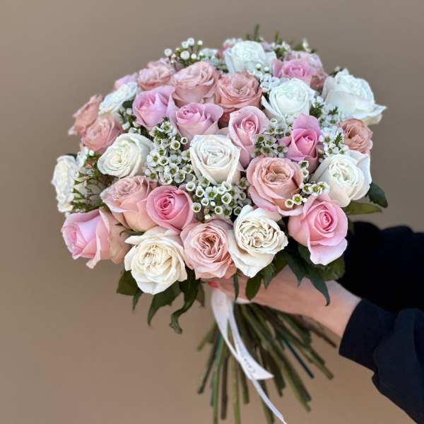 Hand-tied bouquet of pink and white roses with small white filler flowers