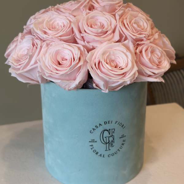 Pink roses arranged in a blue hat box