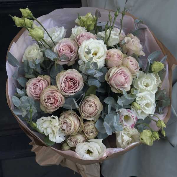Bouquet of blush and white roses with eucalyptus in pink wrap