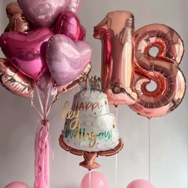 Pink heart balloons and a rose-gold 18 birthday balloon with a cake balloon